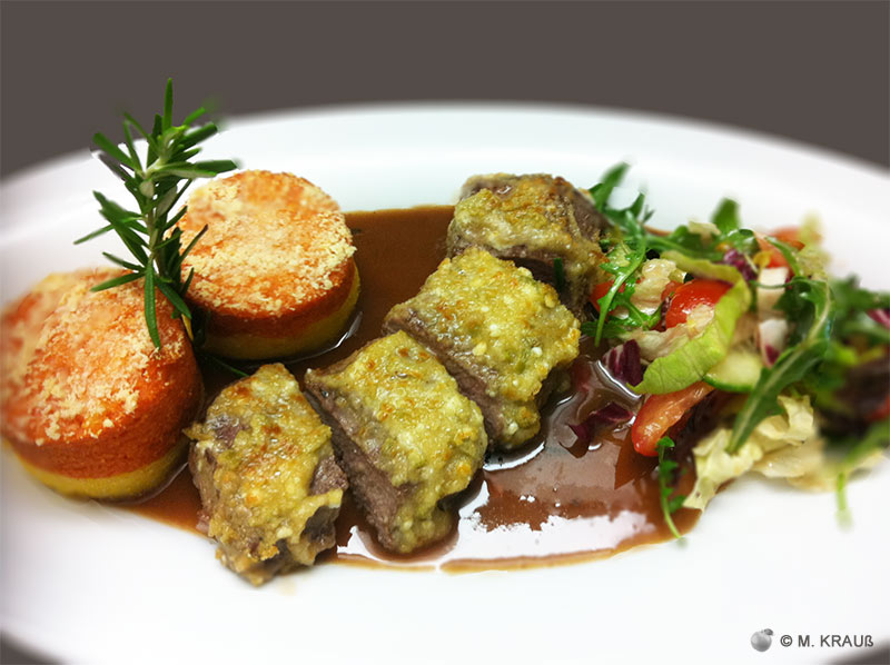 Lammrücken unter der Oliven-Schafskäse-Kruste auf Rotweinsoße mit zweifarbiger Polenta und Sala